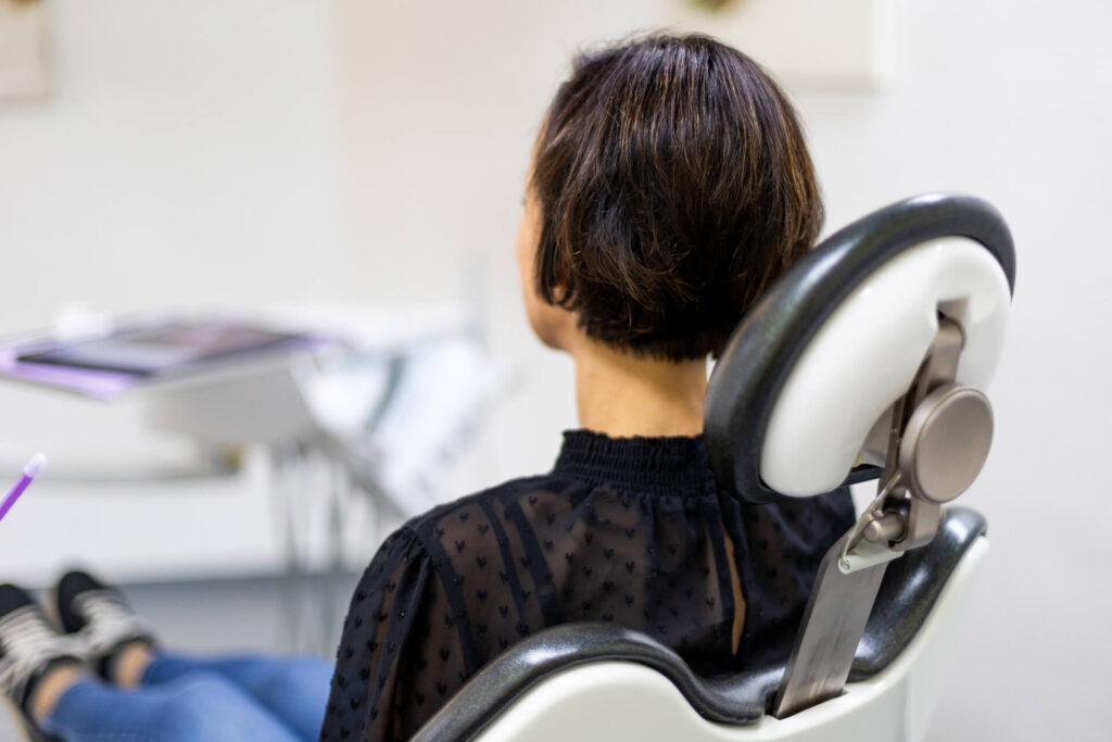 Patientin sitzt auf Behandlungsstuhl | Zahnarzt in Kassel